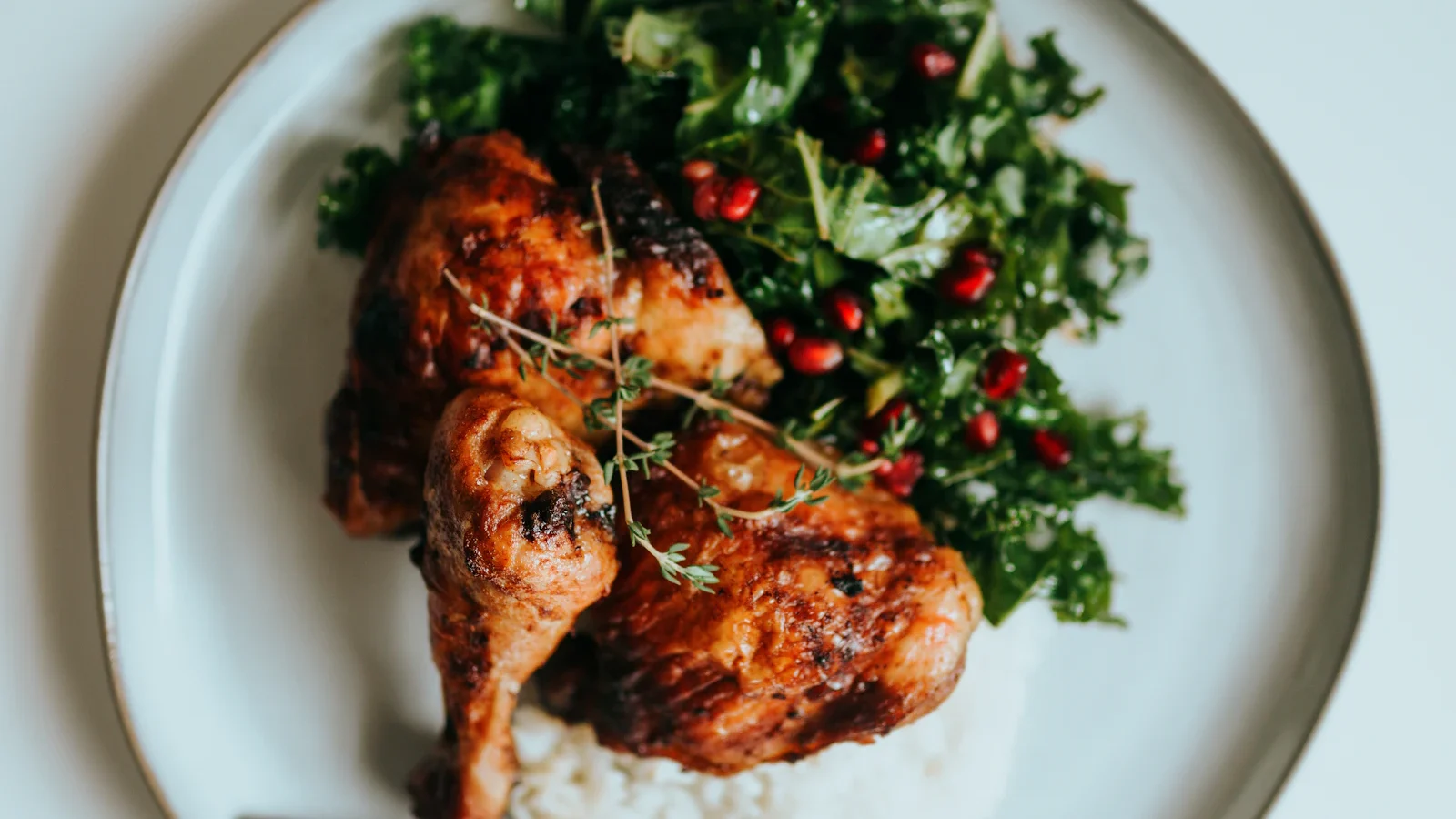 Roast chicken with greens and rice on a white plate